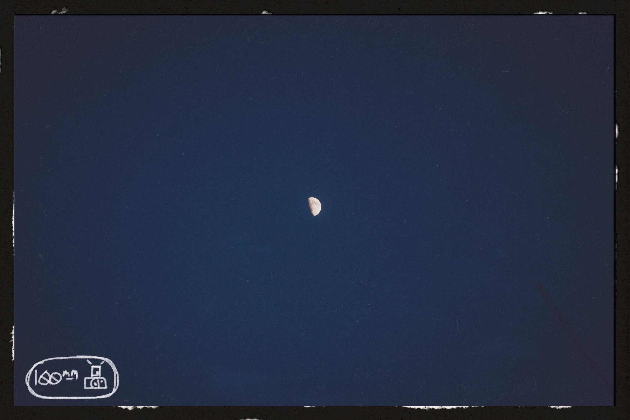 Another shot of the moon, this time from less of a zoom; handwritten in the lower left is the words '100mm' and a badly drawn camera