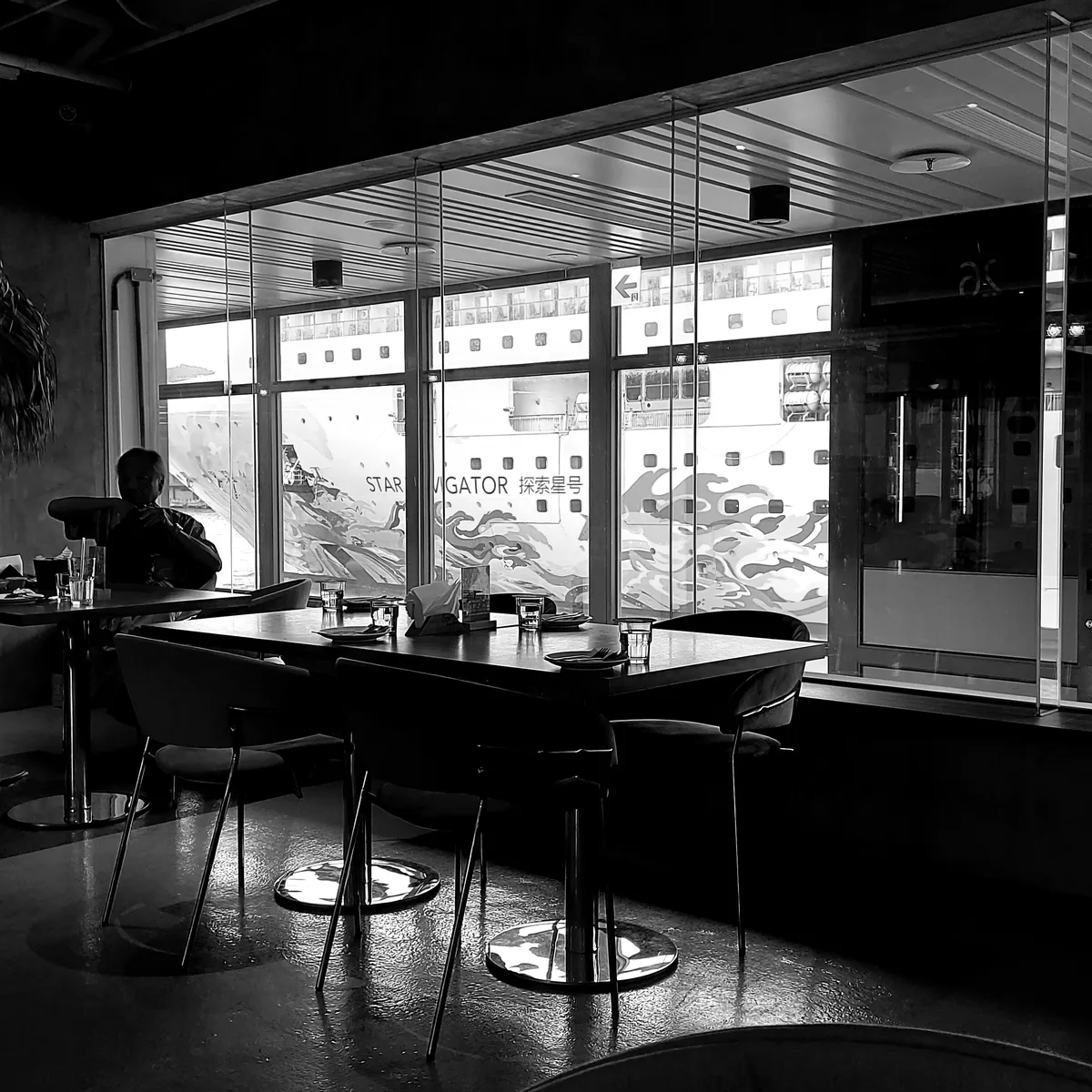 Silhouetted man sitting alone in a cafe