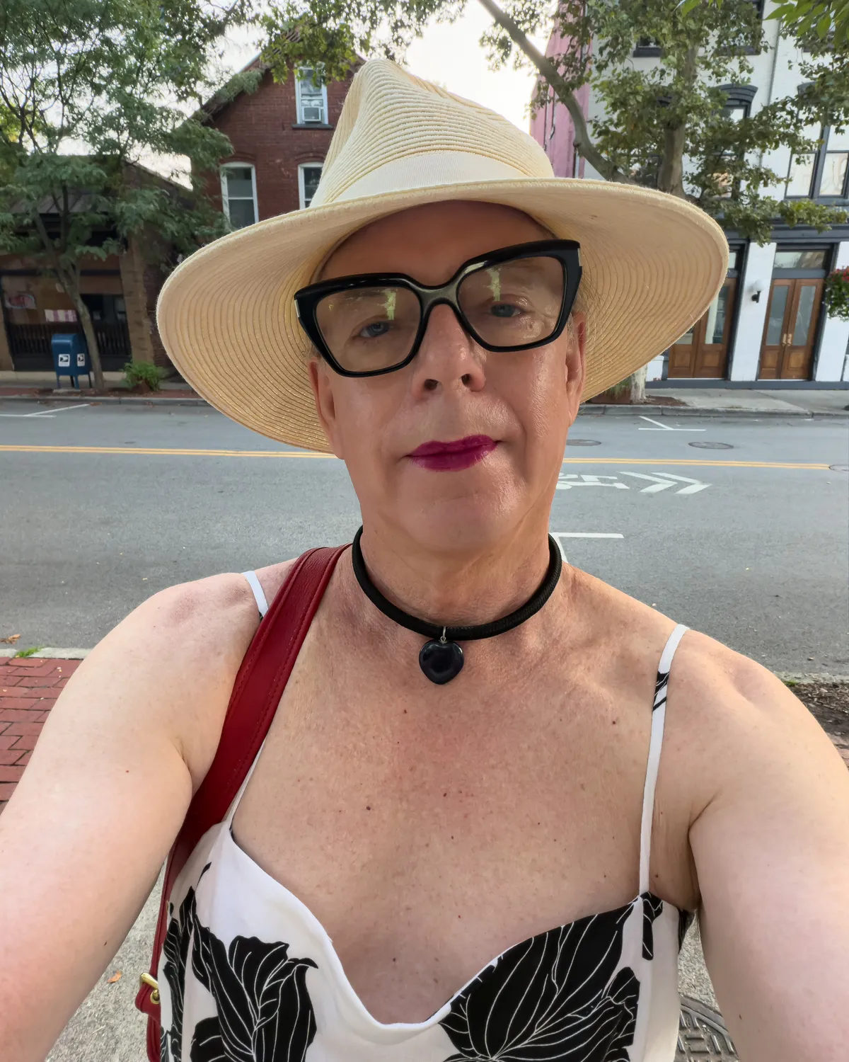self portrait with white straw hat, black frame glasses, soft plum lipstick, choker necklace with heart shaped stone, black and white floral sundress with spaghetti straps IMG_4835
