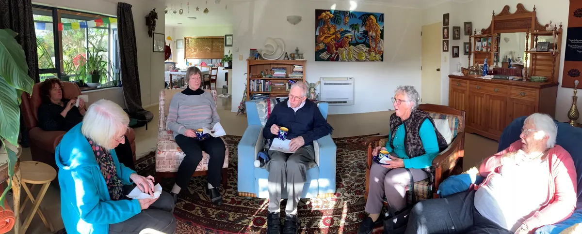 A group of Nelson deafblind network members sitting together in a lounge, with cups of tea and refreshments.