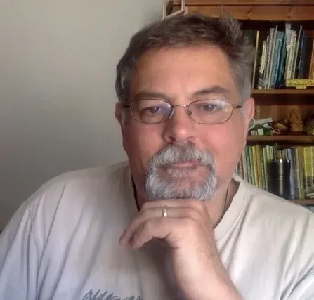 Kevin Prince sits in an office, resting his chin on his propped up hand.
