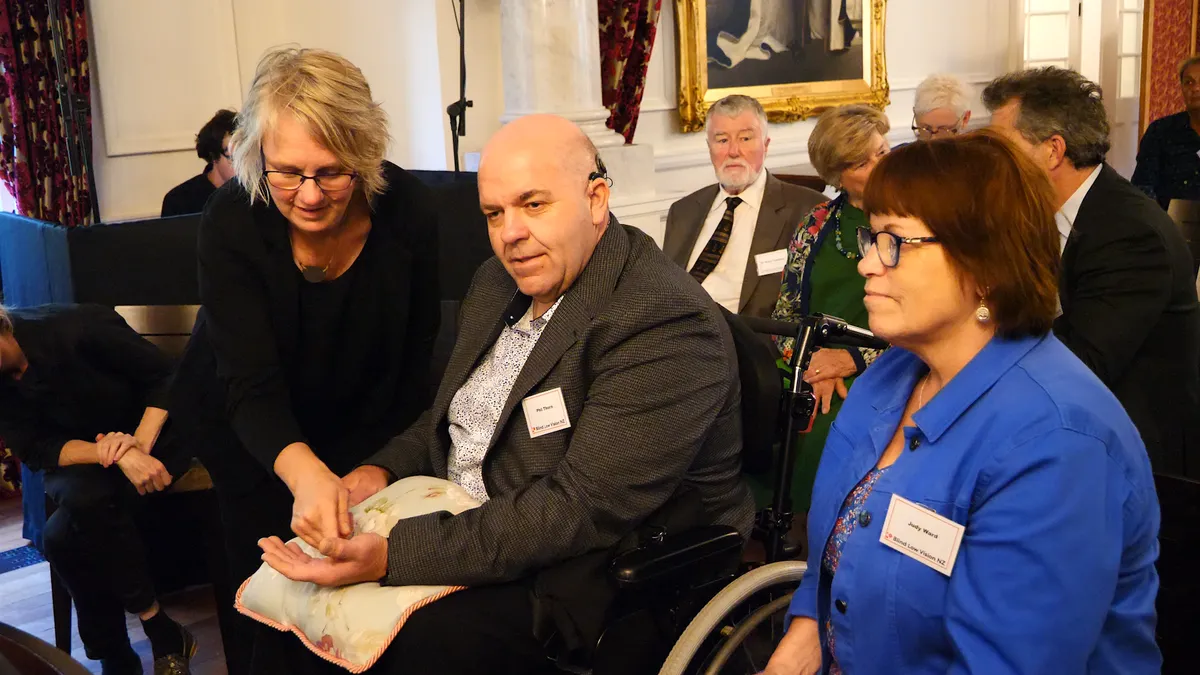 Board member Phil Thorn at Government House in March 2025, with tactile communicators Bridget and Janet.