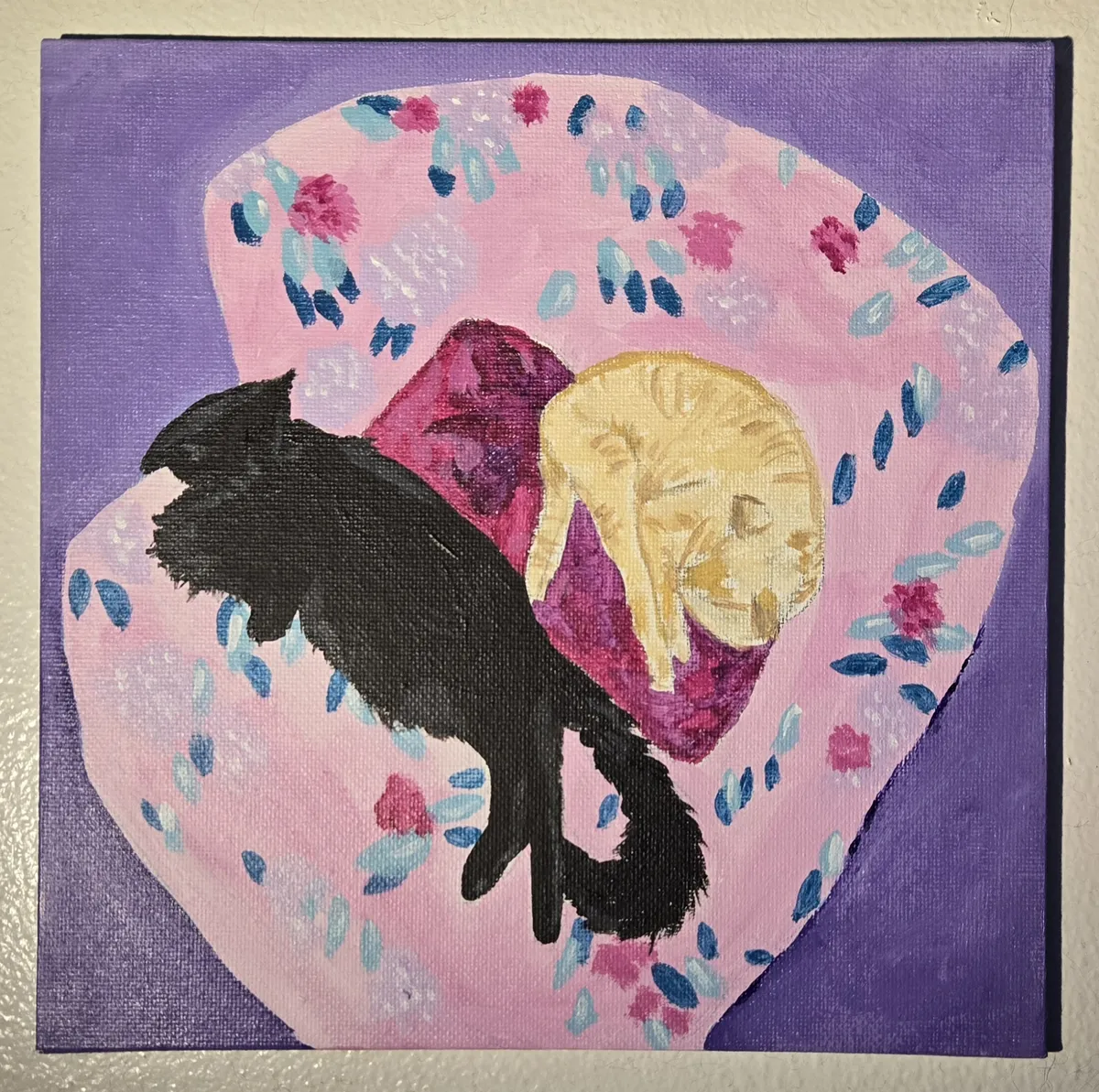 a small acrylic painting of an orange tabby cat and a fluffy black cat sleeping on an oversized chair with a pink and people floral pattern