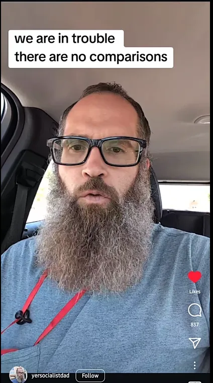 A white man with a gray beard and dark glasses sits in his car. Text above him reads 