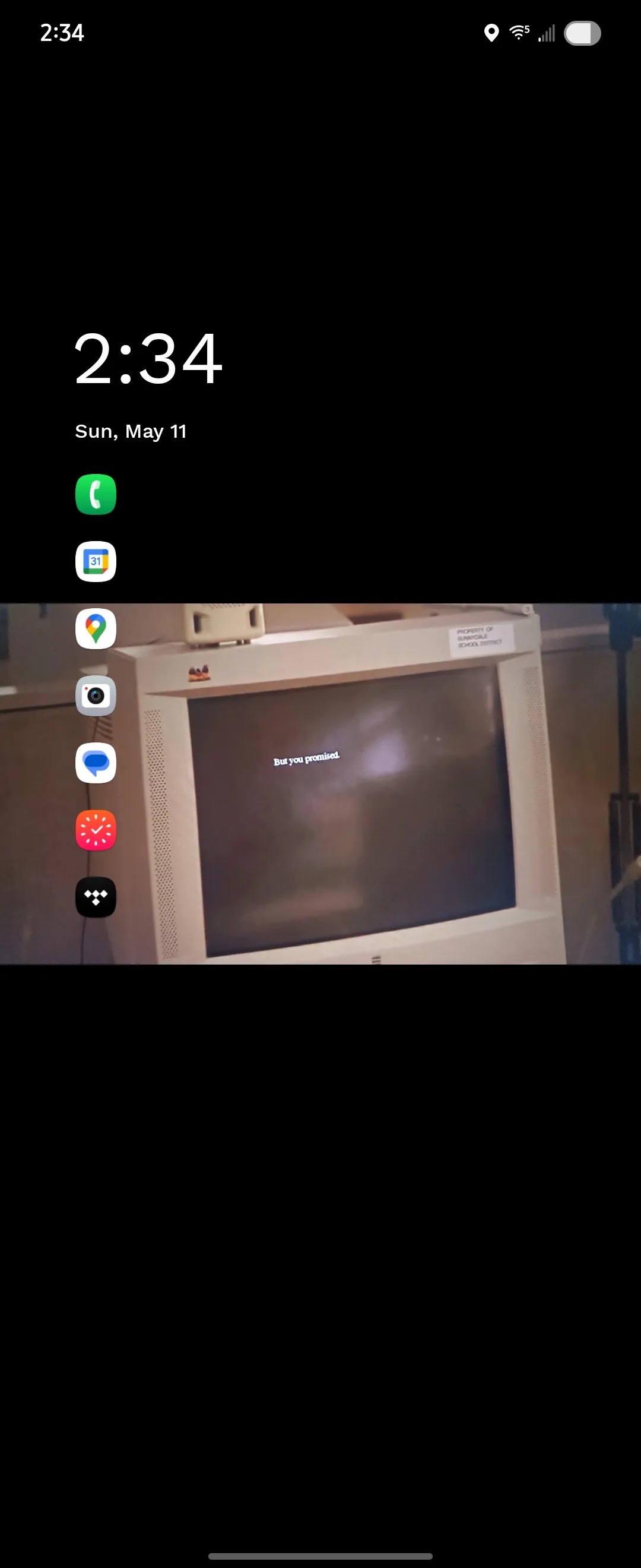 A minimal list of 7 apps are shown beneath the date time, and in the background as a photo of an old computer with text on the screen that reads: But you promised