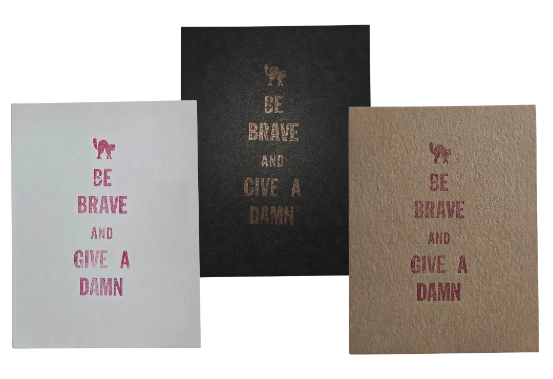 Three letterpress prints side by side, each reads "Be brave and give a damn"