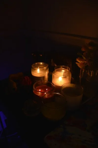a group of scented candles placed on a desk in a dark room