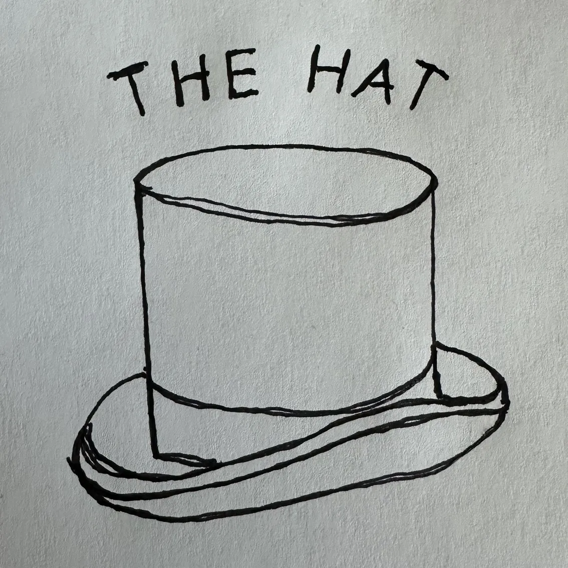 A white piece of paper with a hand-drawn top hat in black ink. The words 'The Hat' are written above the hat.