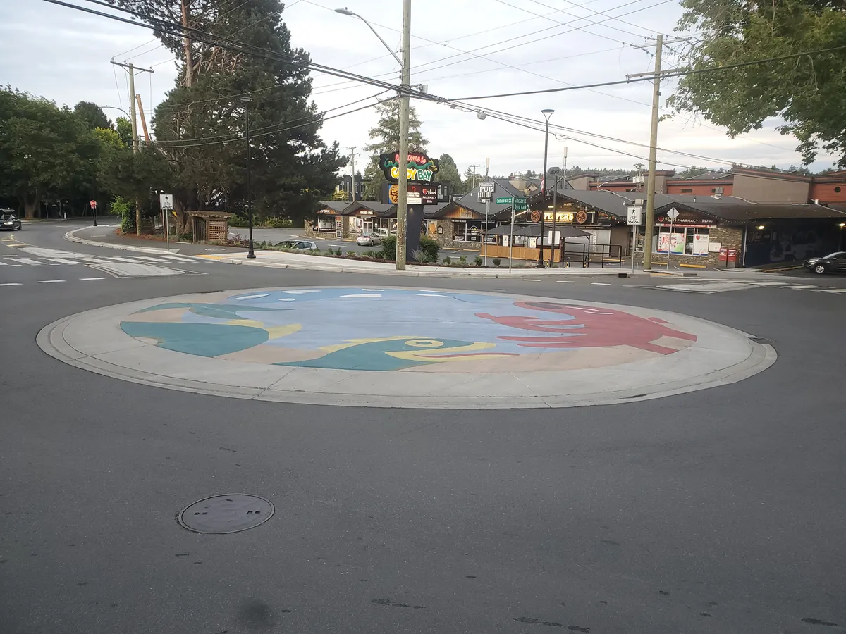 An image of the low, mountable concrete island of the roundabout at Sinclair and Cadboro Bay Road.