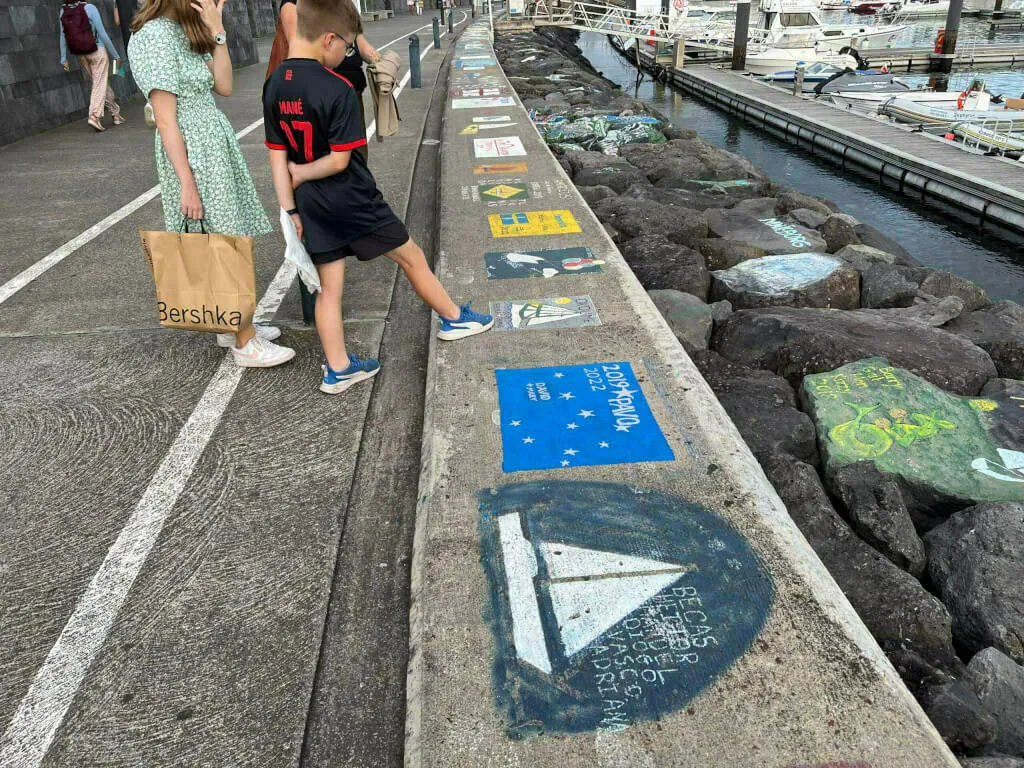 Die auf die Mole gemalten Bilder der Seefahrer im Hafen von Ponta Delgada.