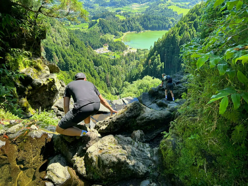 Zwei Deutsche stehen am Rand des Wasserfalls um Fotos zu machen.