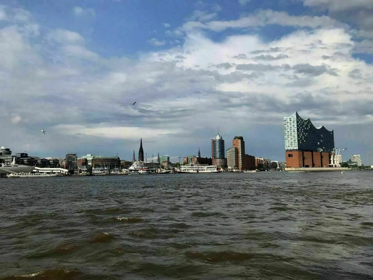 Blick von einer Hadag-Fähre auf die Hamburger Hafen-Skyline mit den im Wasser schaukelnden Wellen zeigt.