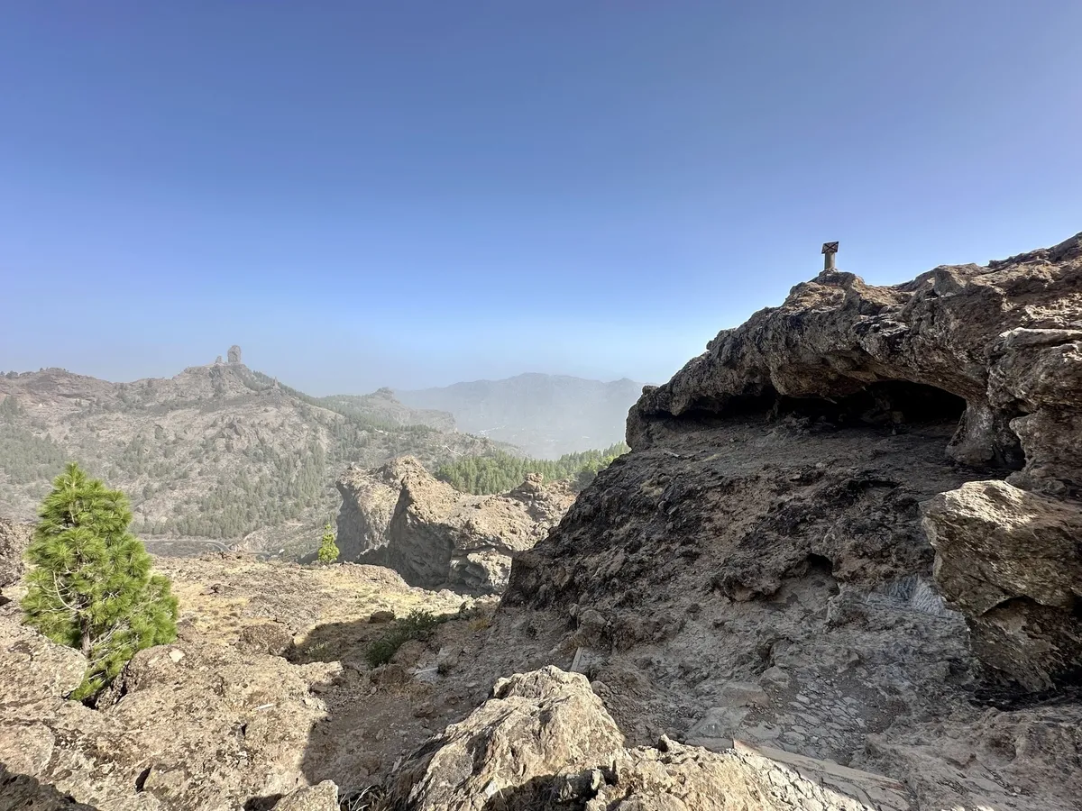 Eine felsige Landschaft mit einem klaren Himmel und einem Aussichtspunkt auf der rechten Seite.