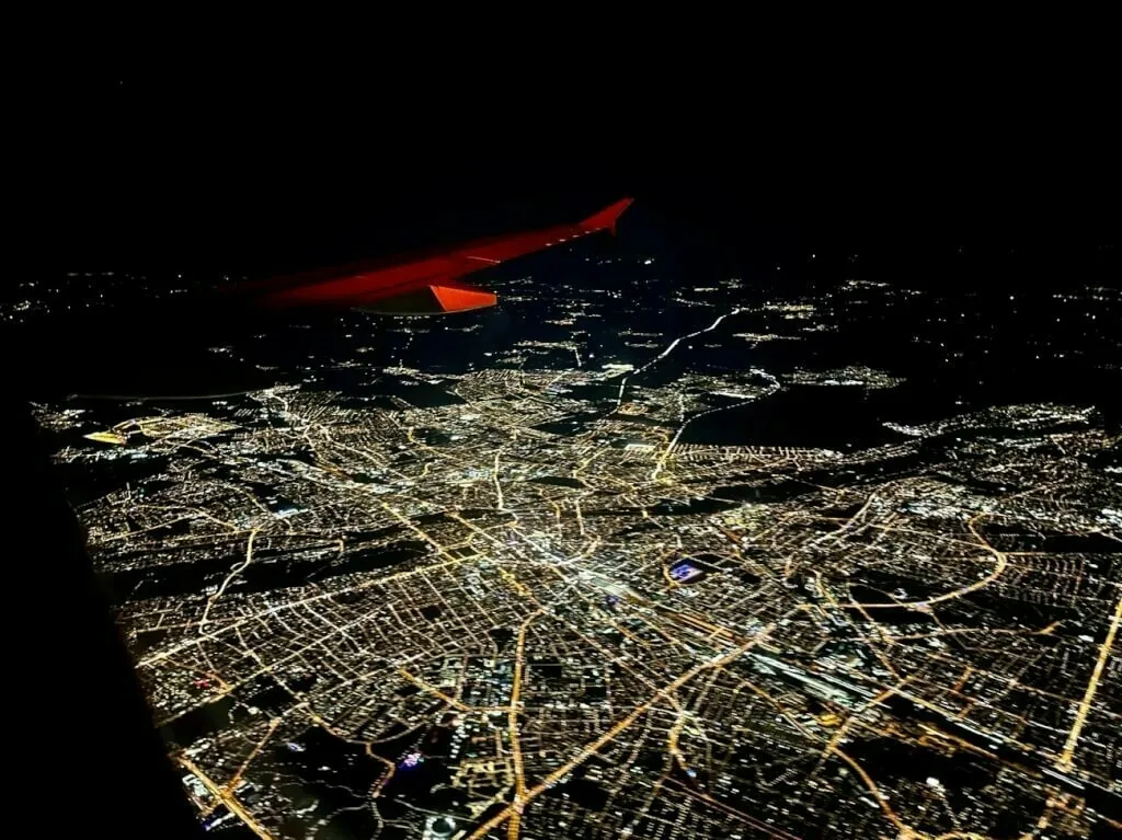 Blick auf das hell erleuchtete nächtliche München von Flug DE1413 aus.