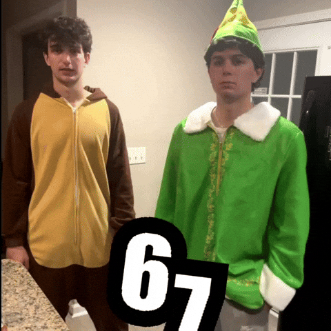 Two young men are standing in a room with light-colored walls. The man on the left is wearing a brown onesie with animal-like ears, while the man on the right is wearing a green elf costume with a white collar. In the foreground, the number "67" is visible in a large font.