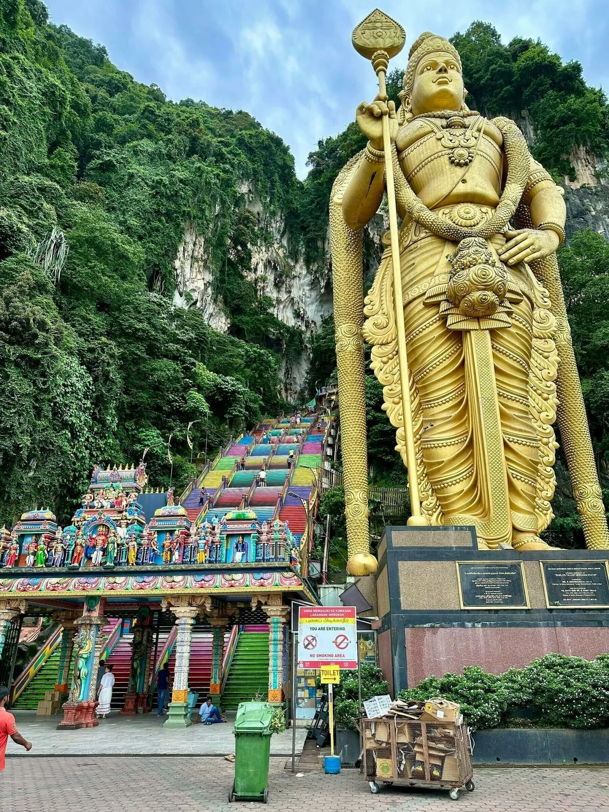 Die goldene Statue von Murugan vor den bunten Stufen zu den Batu Caves.