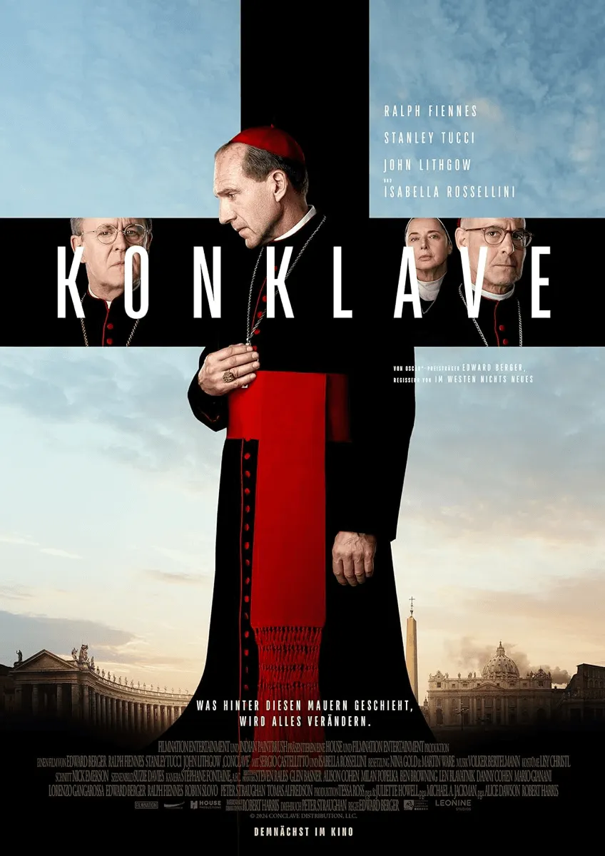 Filmplakat für den Film Konklave (Originaltitel: Conclave). Im Zentrum steht ein Kardinal (gespielt von Ralph Fiennes) in schwarzer Soutane und rotem Schultertuch, der nachdenklich nach unten blickt. Er trägt einen Zingulum-Ring und ein Brustkreuz. Über ihm, in den vier Quadranten eines schwarzen Kreuzes, sind Porträts weiterer Hauptdarsteller zu sehen: John Lithgow, Isabella Rossellini, Stanley Tucci und ein weiterer Kardinal. Oben stehen die Namen der Stars. Der Filmtitel KONKLAVE ist in großen, weißen Buchstaben in die schwarze Leiste integriert. Unten ist die Fassade des Petersdoms und des Vatikans zu sehen. Der Text lautet: "WAS HINTER DIESEN MAUERN GESCHIEHT, WIRD ALLES VERÄNDERN."