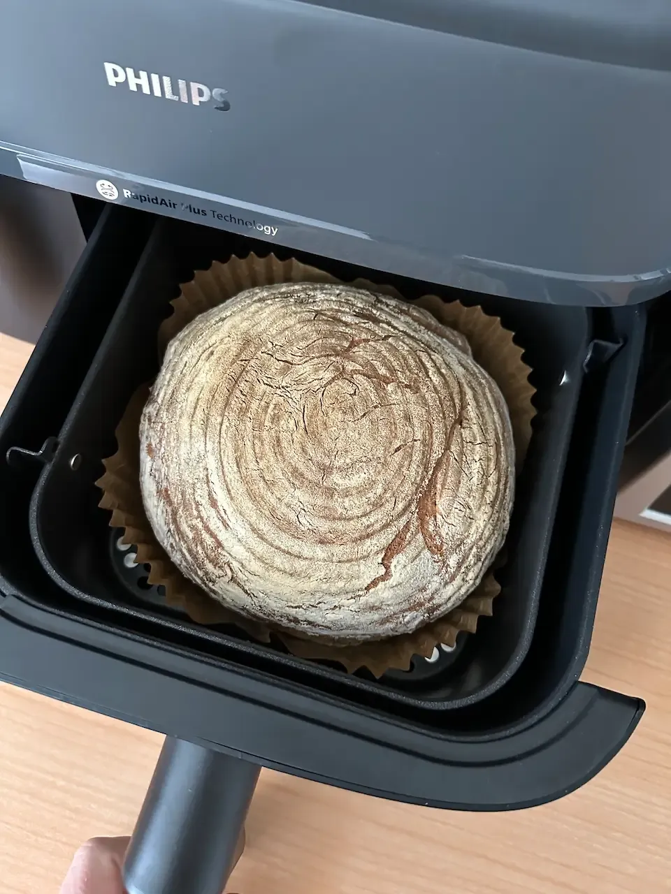 Ein rundes Brot wird in einer Philips Heißluftfritteuse gebacken.