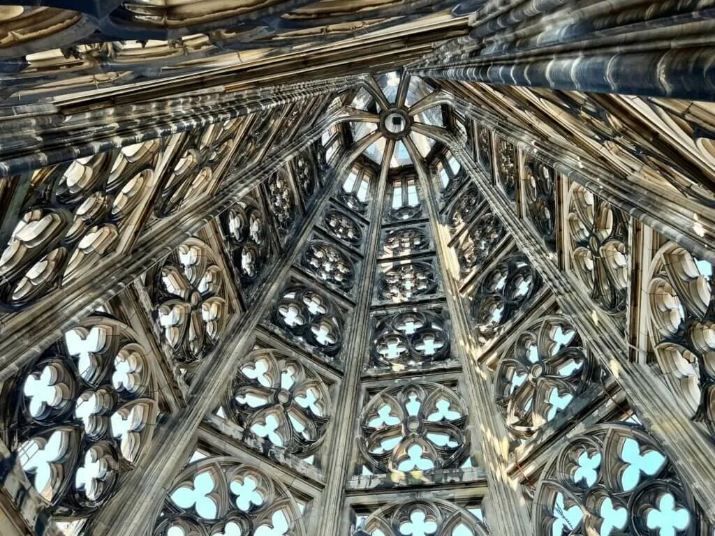 Spektakuläre Aufsicht in die komplizierte gotische Turmkonstruktion des Kölner Doms mit filigranen Steinmetzarbeiten und Rosetten.