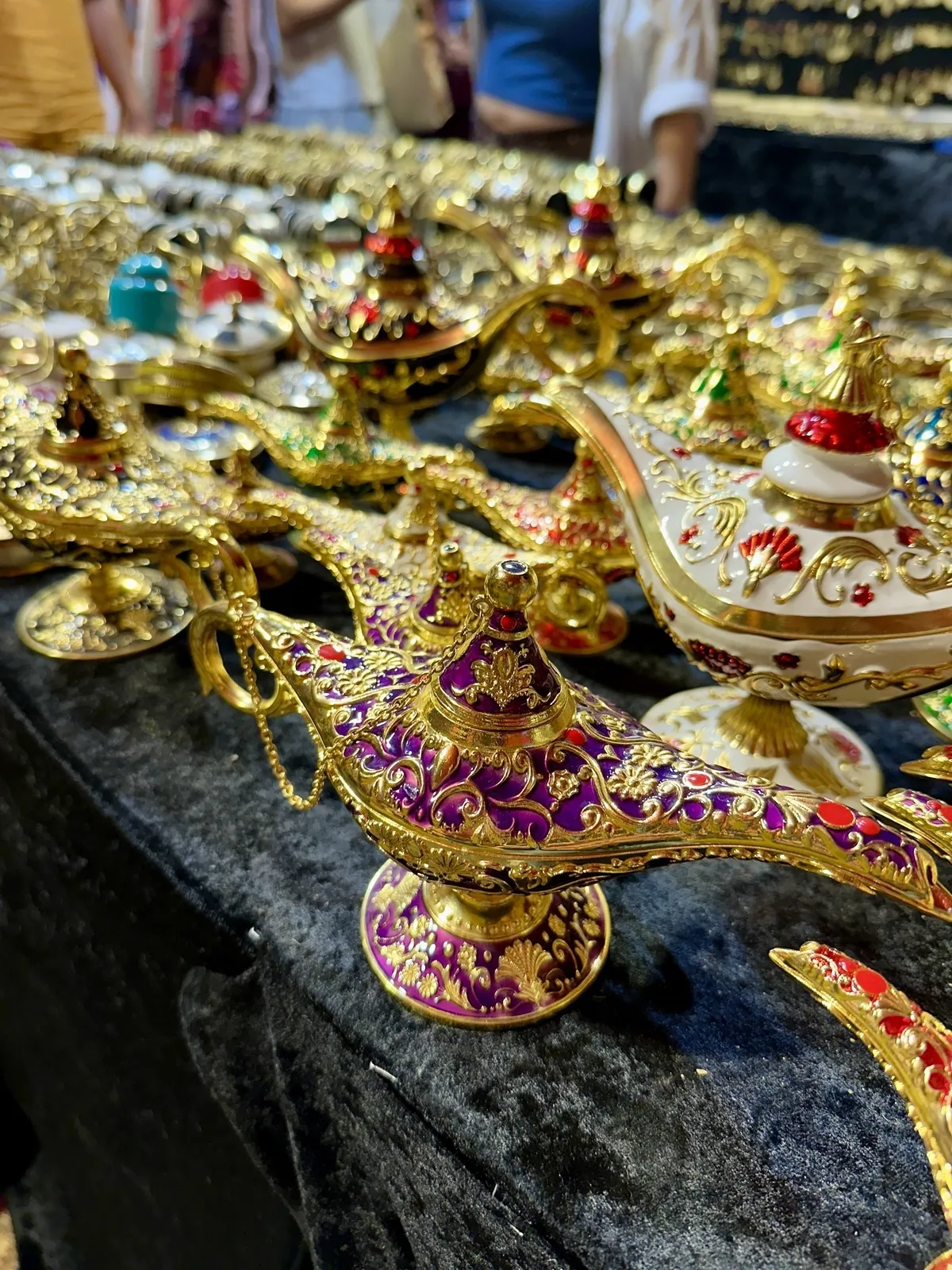 Vergoldete und reich verzierte Aladin-Lampen sind auf einem Tisch ausgestellt.
