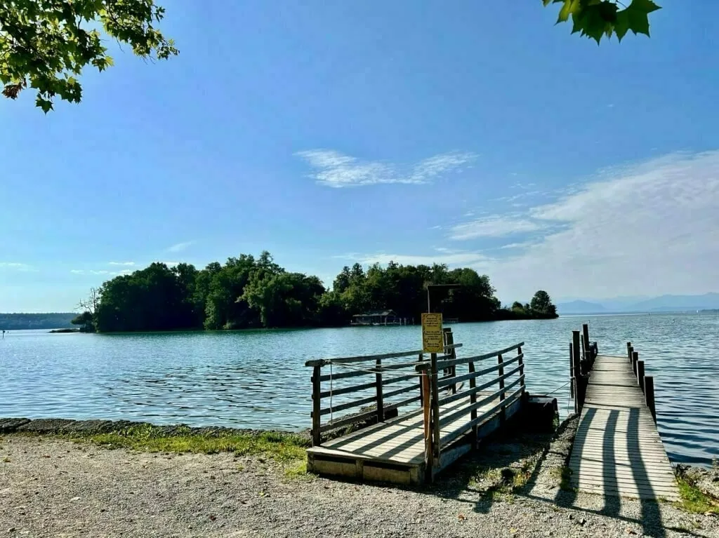 Blick über den Bootsanleger auf die Roseninsel am Starnberger See.