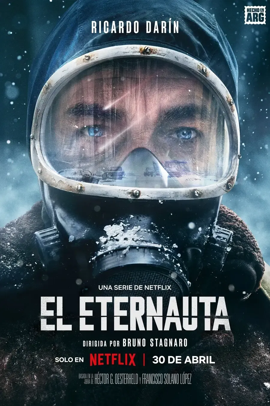 Nahaufnahme eines dramatischen Filmplakats für die argentinische Netflix-Serie El Eternauta. Es zeigt den Hauptdarsteller Ricardo Darín, der eine dicke Kapuze und eine Atemmaske mit einer beschlagenen Schutzbrille trägt. Seine hellblauen Augen blicken eindringlich nach vorne. Am oberen Rand steht sein Name Ricardo Darín, und der Titel EL ETERNAUTA dominiert den unteren Bereich. Darunter steht: "EINE SERIE VON NETFLIX", "REGIDA POR BRUNO STAGNARO" und "SOLO EN NETFLIX | 30 DE ABRIL". Oben rechts ist ein Logo mit dem Text "HECHO EN ARG" zu sehen.