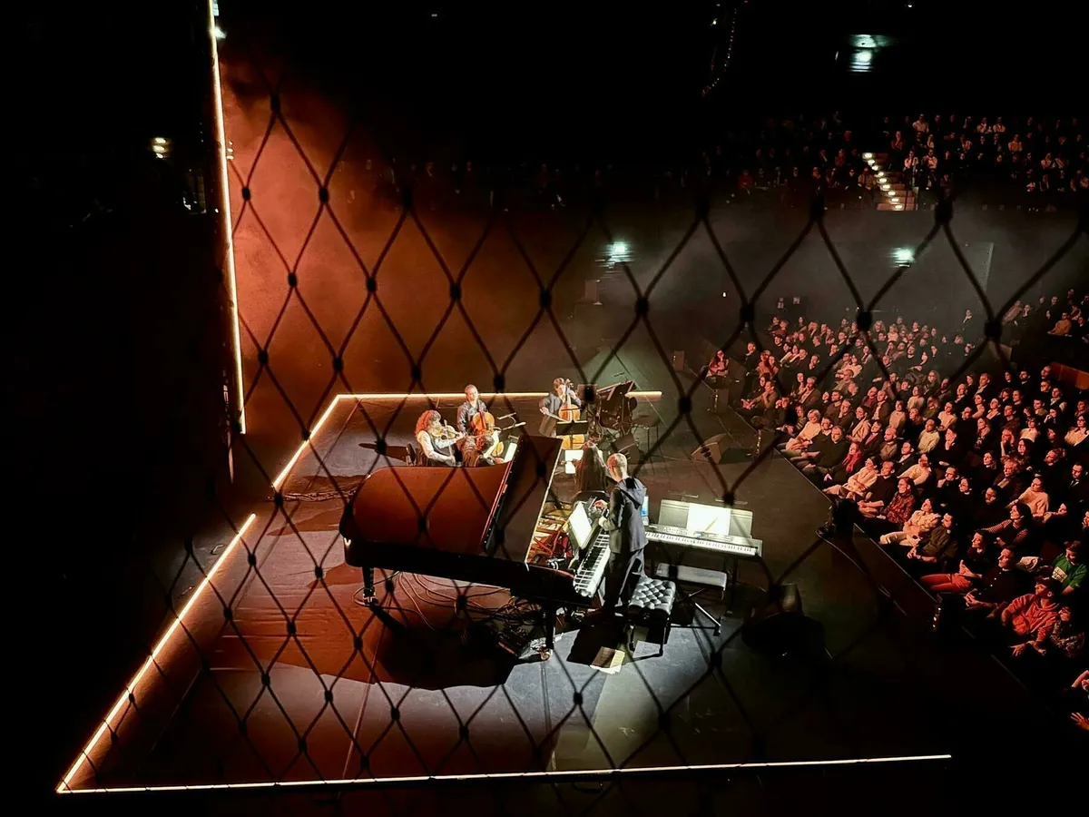Max Richter spielt auf der Bühne der  Isarphilharmonie mit einem Piano während das Publikum  im Saal sitzt.