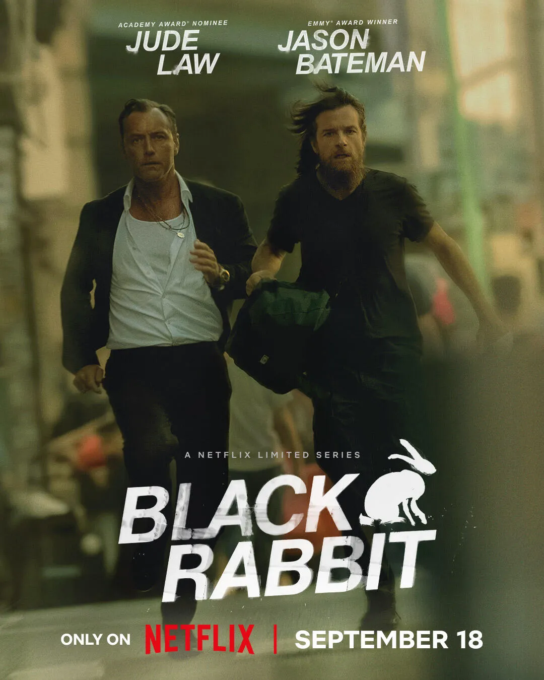 Zwei Männer in schickem und lässigem Outfit stehen in einer urbanen Umgebung. Der Titel "BLACK RABBIT" ist prominent in der Mitte des Bildes platziert, mit dem Veröffentlichungsdatum "SEPTEMBER 18" und der Notiz "ONLY ON NETFLIX" am unteren Rand.