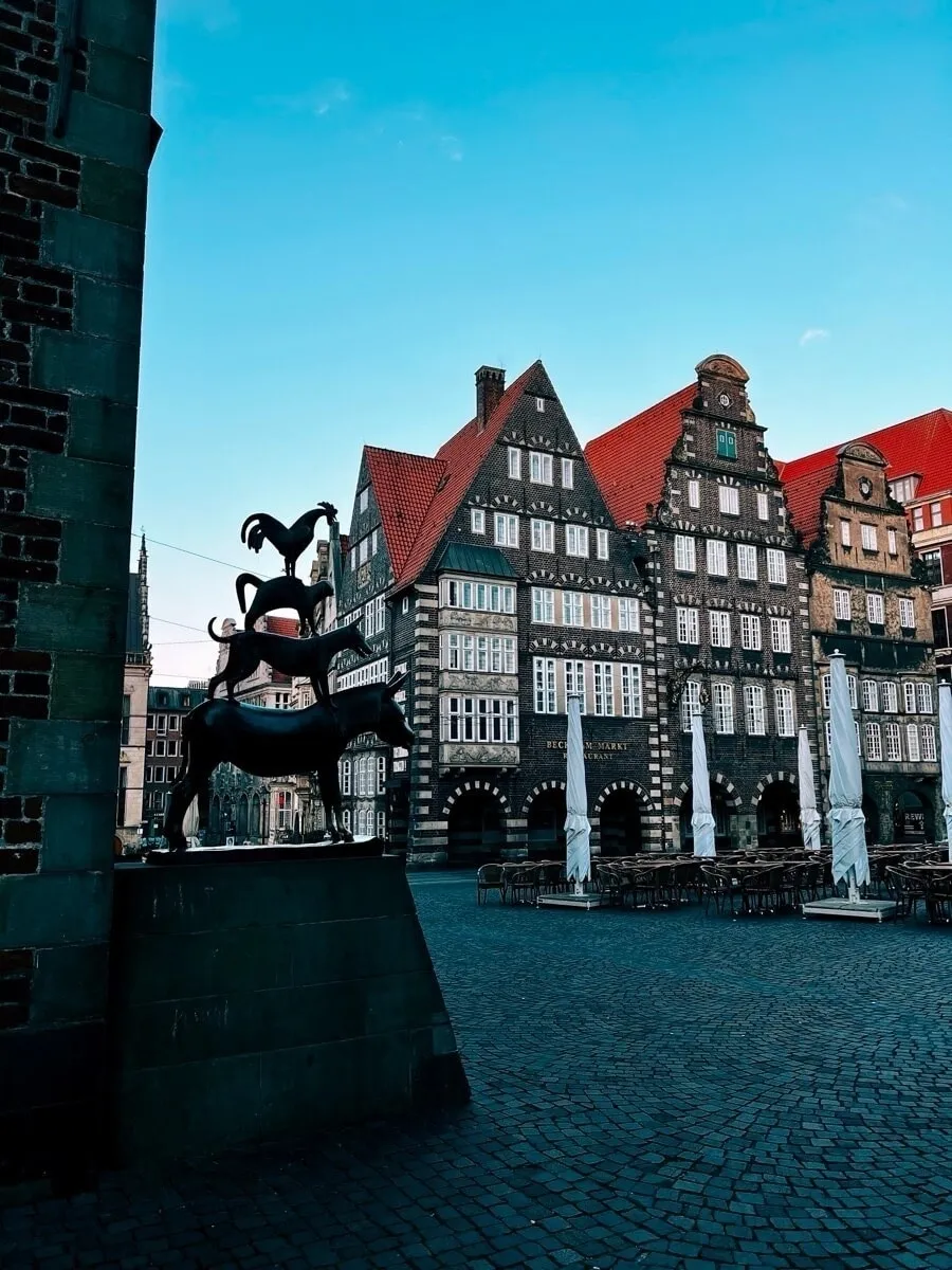 Marktplatz von Bremen im Morgengrauen. Blick über die Bremer Stadtmusikanten hin zum Deutschen Haus.