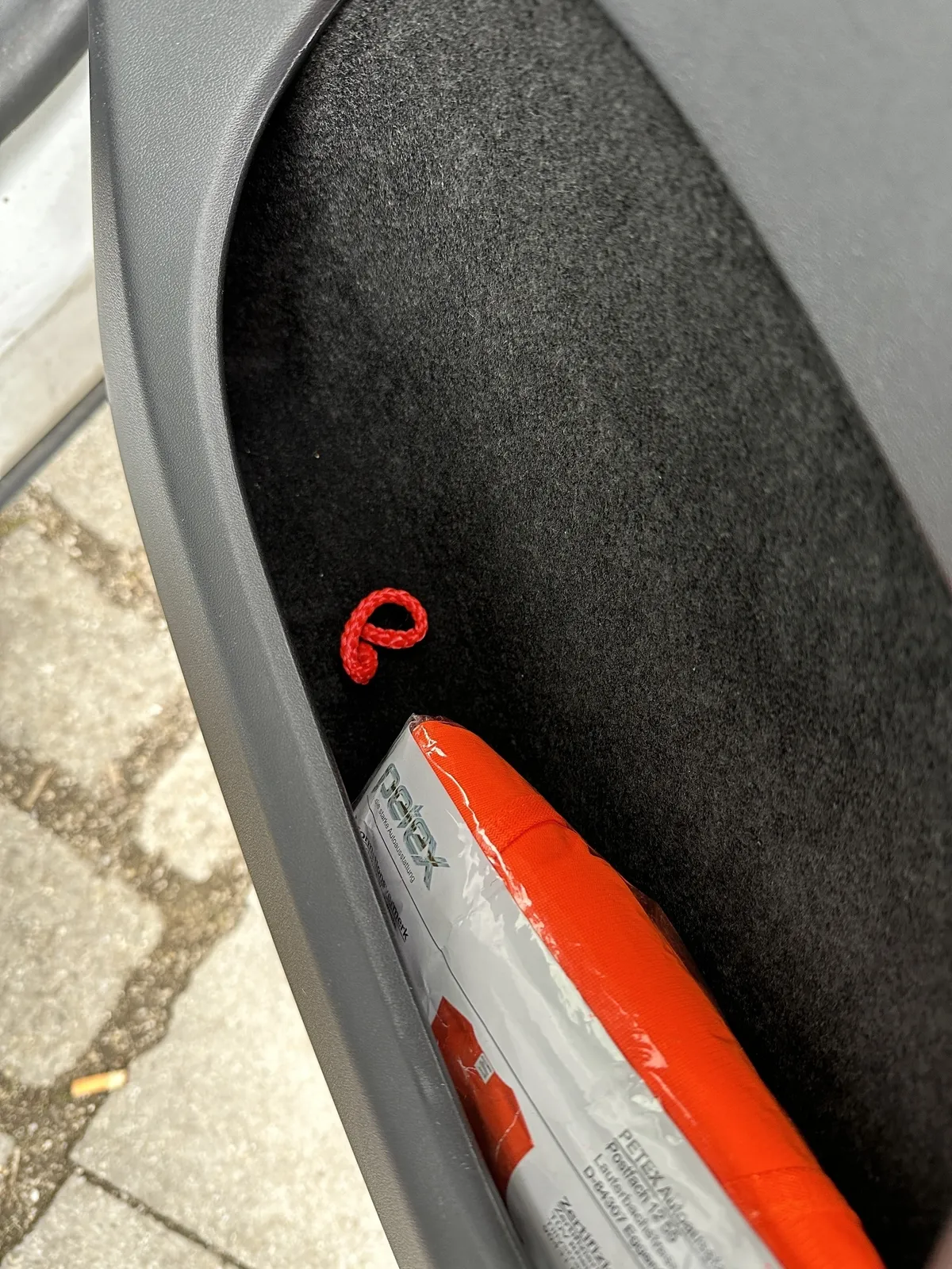 Eine Warnweste liegt neben einer handgemachten Notentrieglung eines Tesla Model Y.