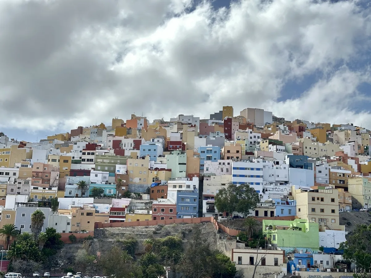 Bunte Häuser erstrecken sich den Hügel hinauf unter einem bewölkten Himmel in Las Palmas, Gran Canaria.