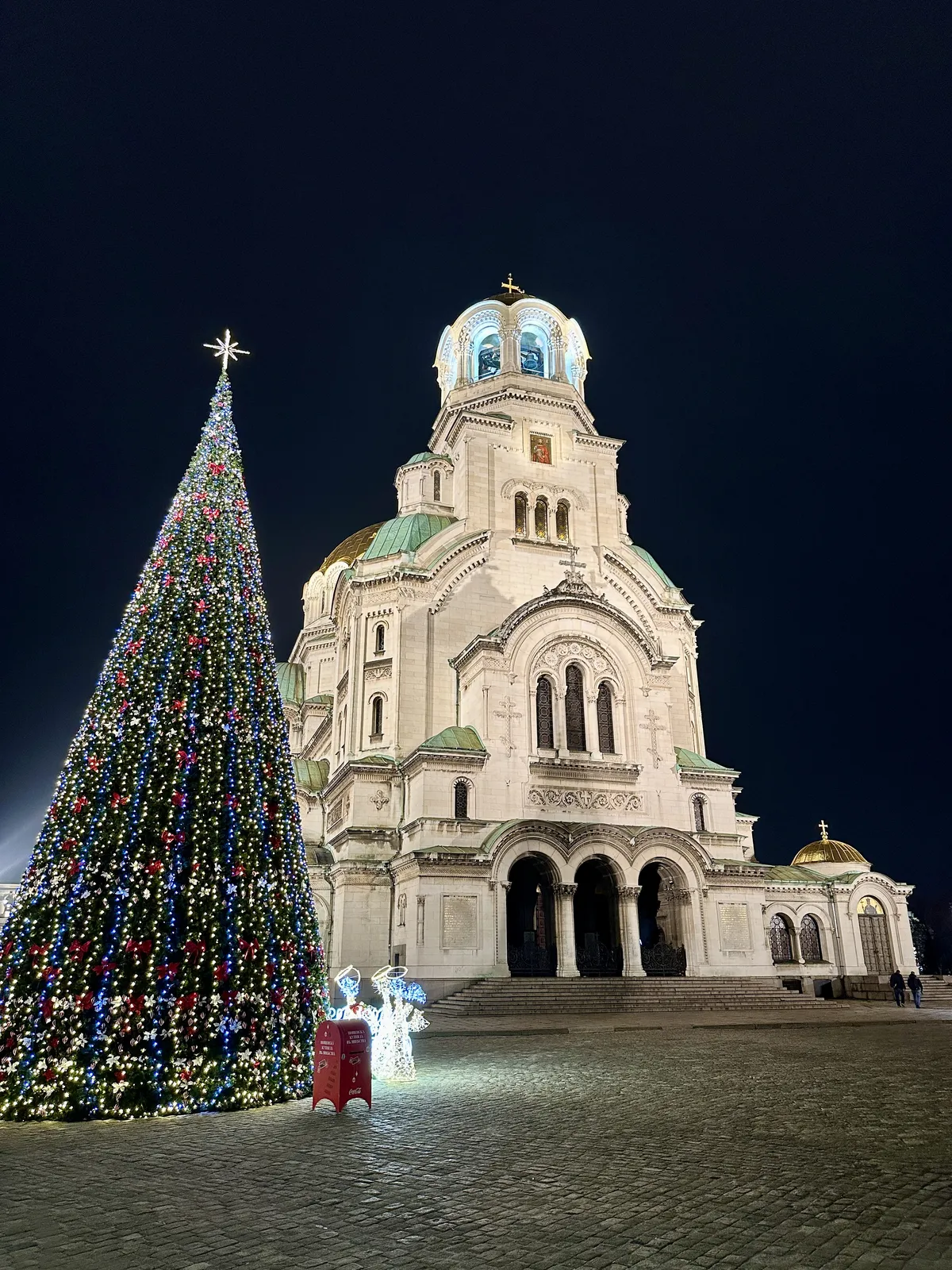Ein festlich beleuchteter Weihnachtsbaum steht neben der beleuchteten Alexander-Newski-Kathedrale in Sofia.