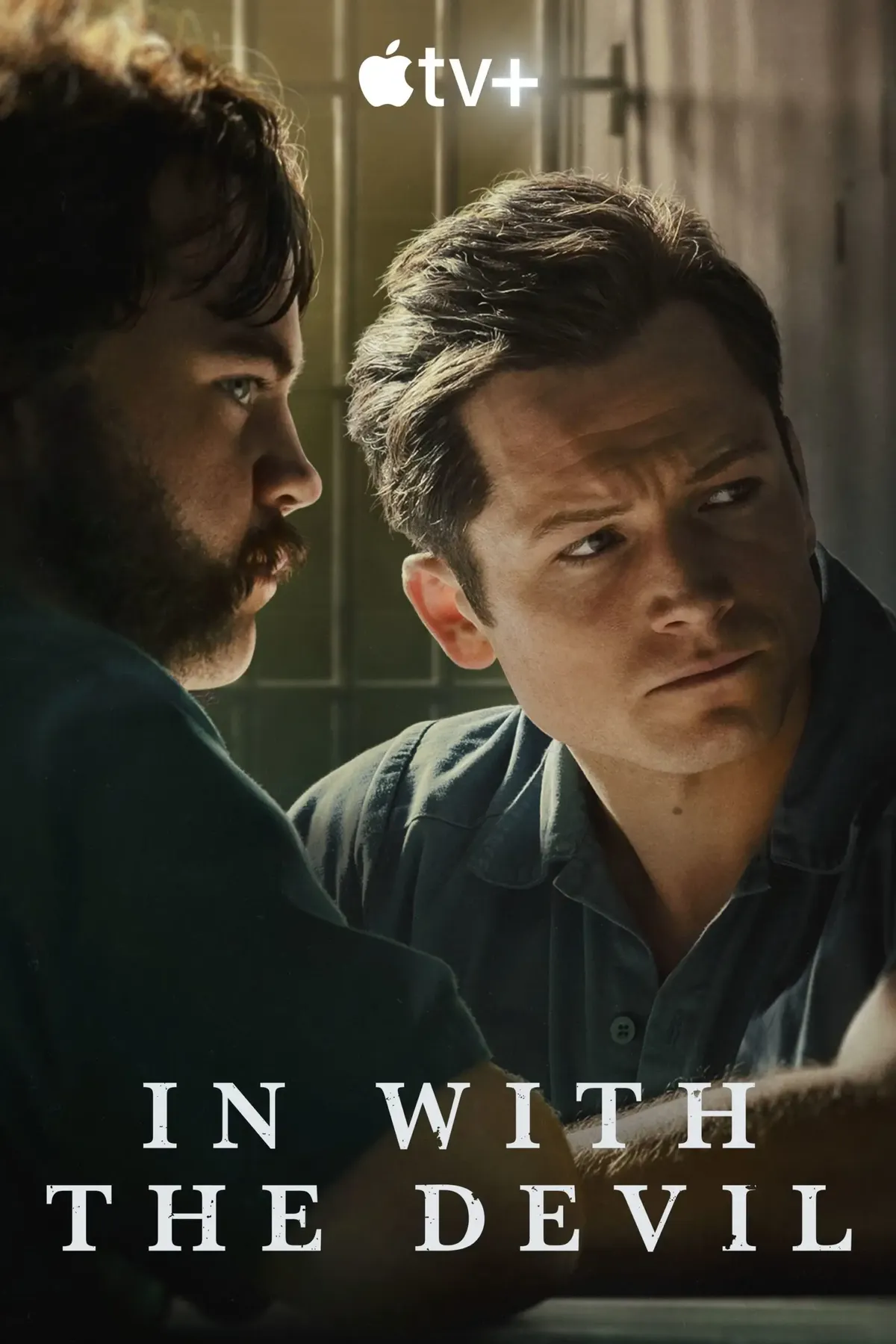 Zwei Männer unterhalten sich angespannt in einem Raum mit Gitterstäben im Hintergrund.