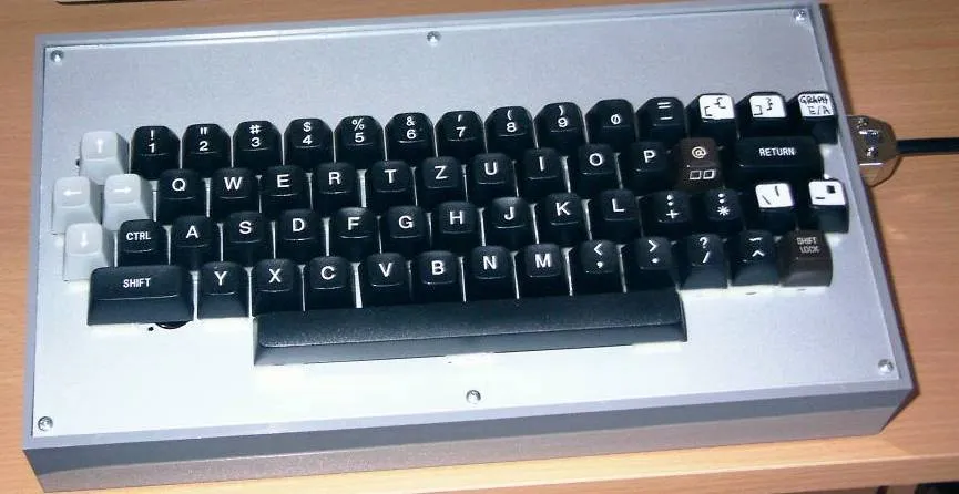 Ein Robotron Z 1013 mit schwarzen und grauen Tasten, die eine QWERTZ-Anordnung aufweist. Der Rahmen ist silberfarben und die Tastatur hat eine kompakte Bauweise.