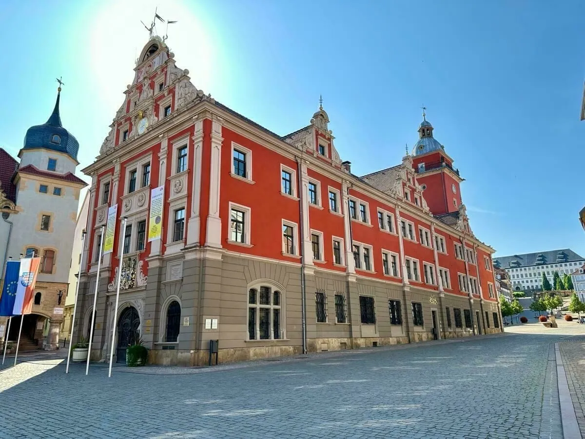 Das historische Rathaus von Gotha mit reich verzierten Elementen steht an einem sonnigen Tag neben einem gepflasterten Platz.