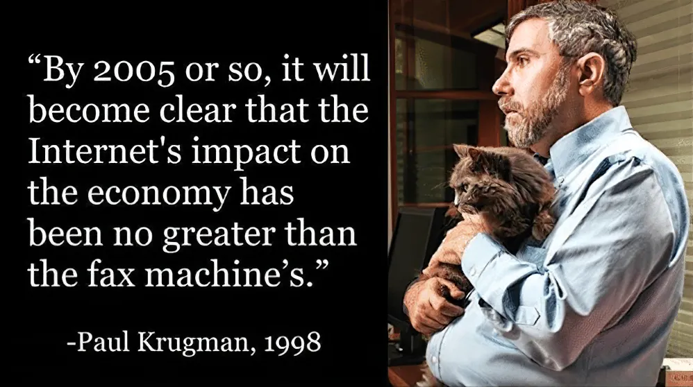 Ein Porträtfoto des Ökonomen Paul Krugman, der nachdenklich zur Seite blickt und dabei eine flauschige, graue Katze im Arm hält. Links daneben steht auf schwarzem Hintergrund ein Zitat von ihm aus dem Jahr 1998: "By 2005 or so, it will become clear that the Internet's impact on the economy has been no greater than the fax machine's."