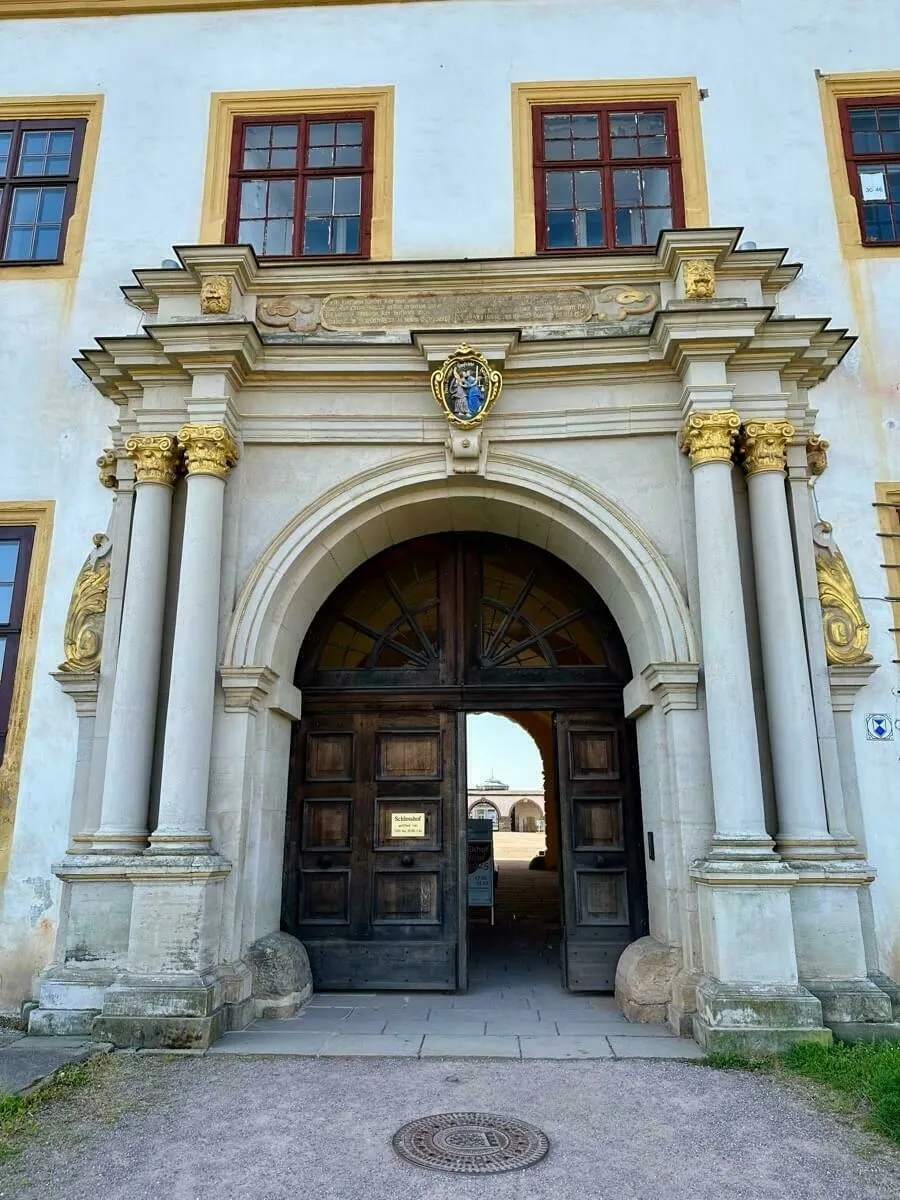 Das aufwendig verzierte steinerne Eingangsportal mit einer großen Holztür vom Schloss Friedenstein.