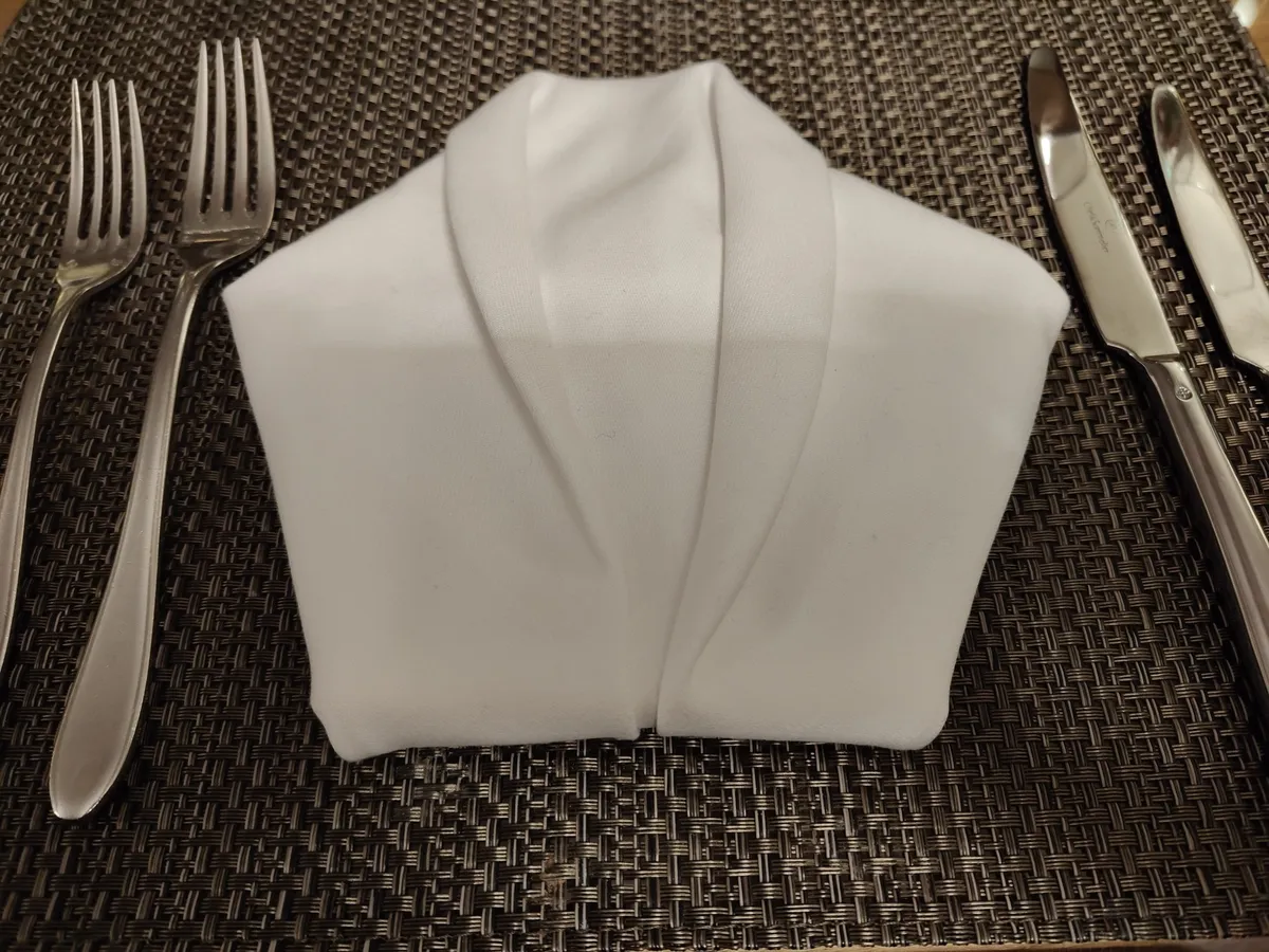 a white napkin folded into a shape of a shirt.