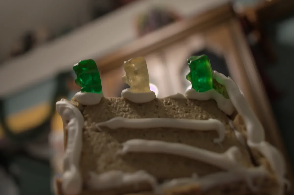 The three gummy bears atop the house, playing "dangerously." The living room in the background is blurred.