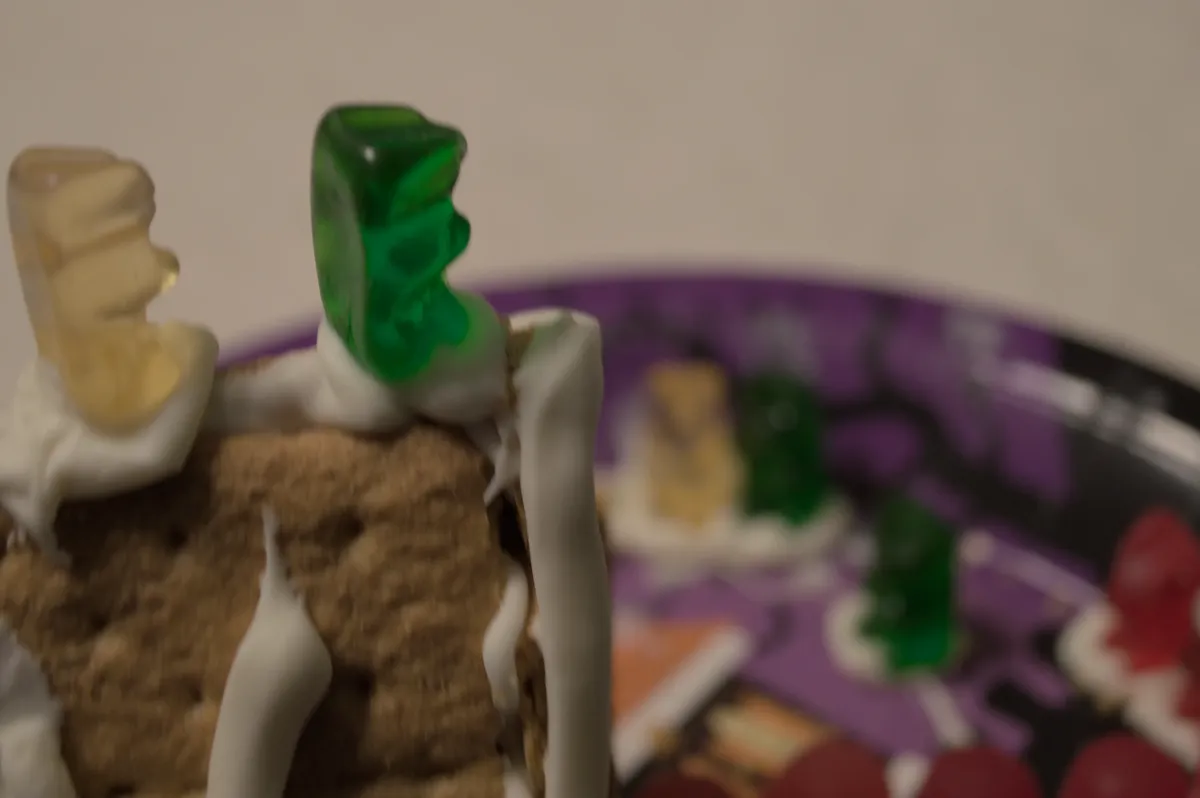 Two of the gummy bears stand on the bow of the roof. The onlookers are seen in the background, but are blurred.