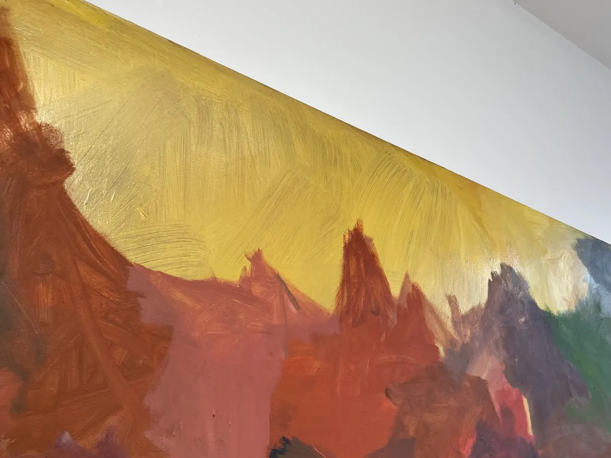 The top edge of a painting, showing a yellow patch with brushstrokes that point downward at angles