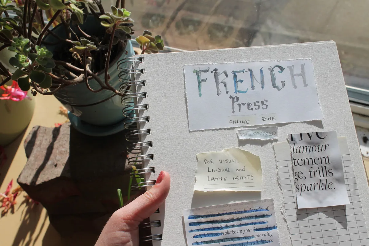 Planning the layout of an issue of French Press zine using watercolour text for the title