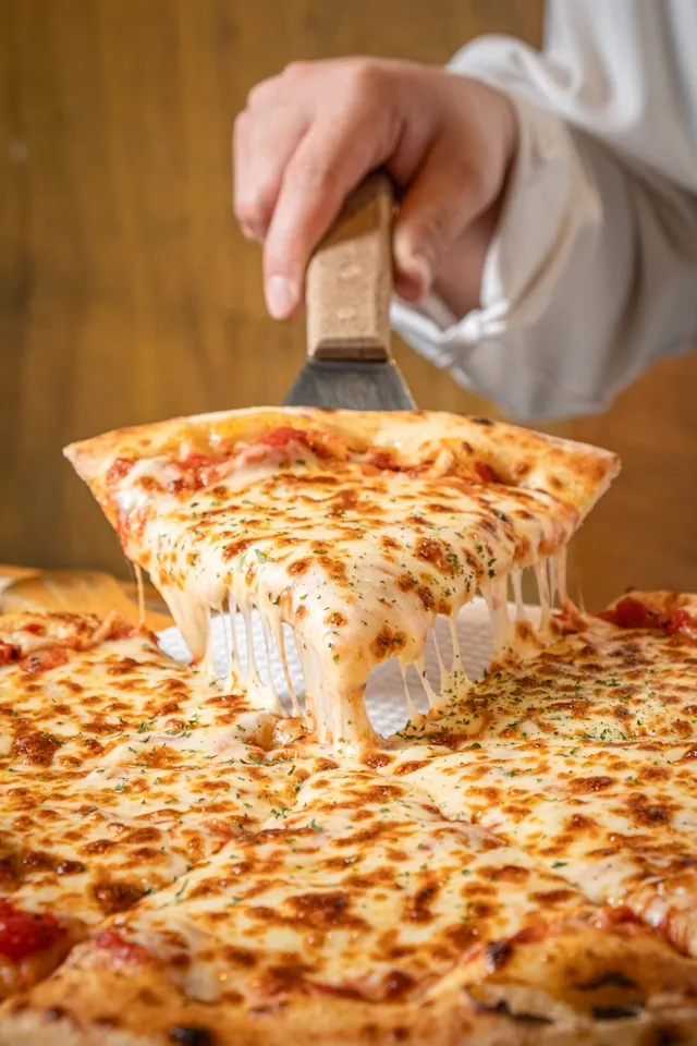 “cheese-pizza-being-dished-up"