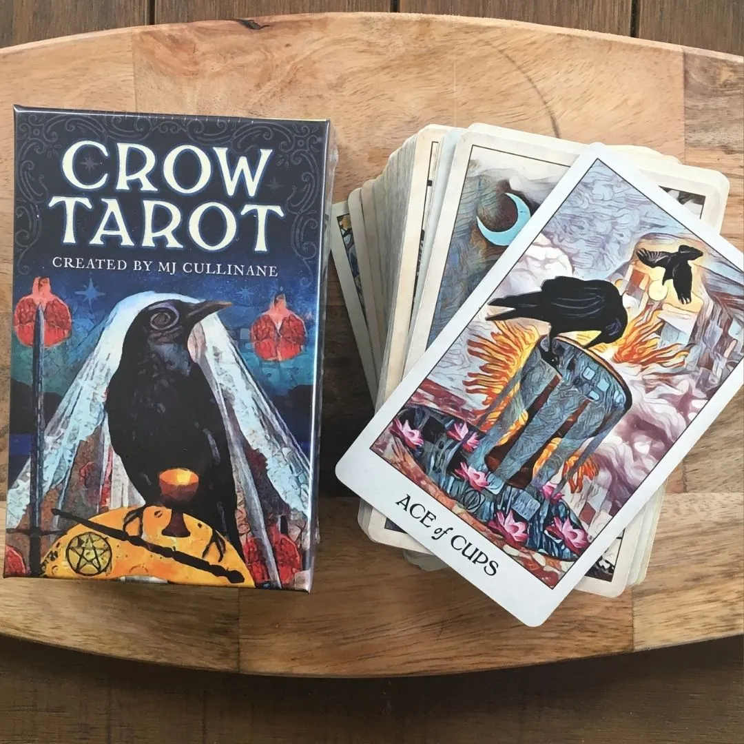 Picture of the box for the Crow Tarot, along with the stack of cards. The crows appear stylized and somewhat abstracted.