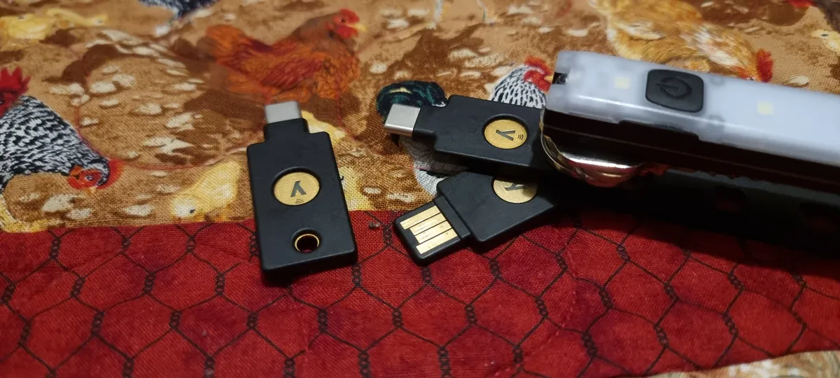 An image of my YubiKeys, two of them are in a Keyport Pivot 2.0, one is laying in front of them