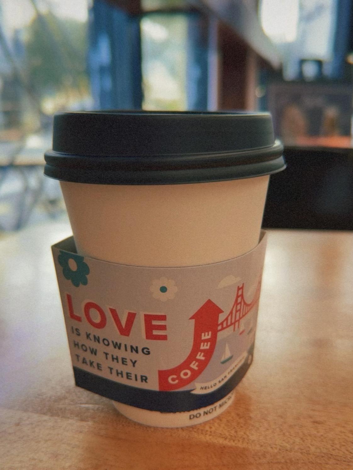 A coffee cup that has a sleeve that says LOVE is knowing how they take their coffee