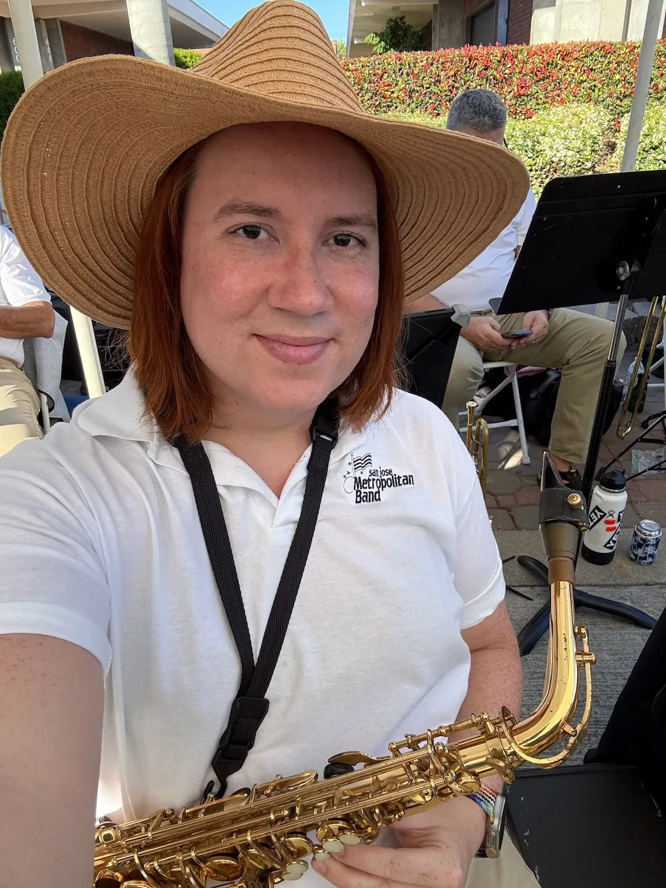A woman in a straw hat holding a saxophone