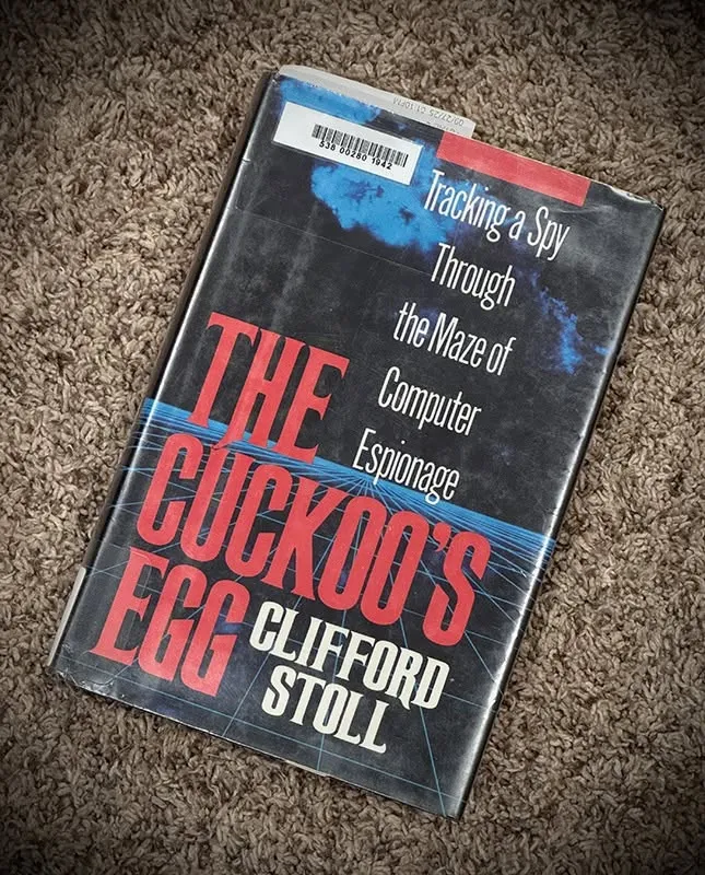 Hardcover copy of The Cuckoo's Egg by Clifford Stoll, with a library barcode on the jacket