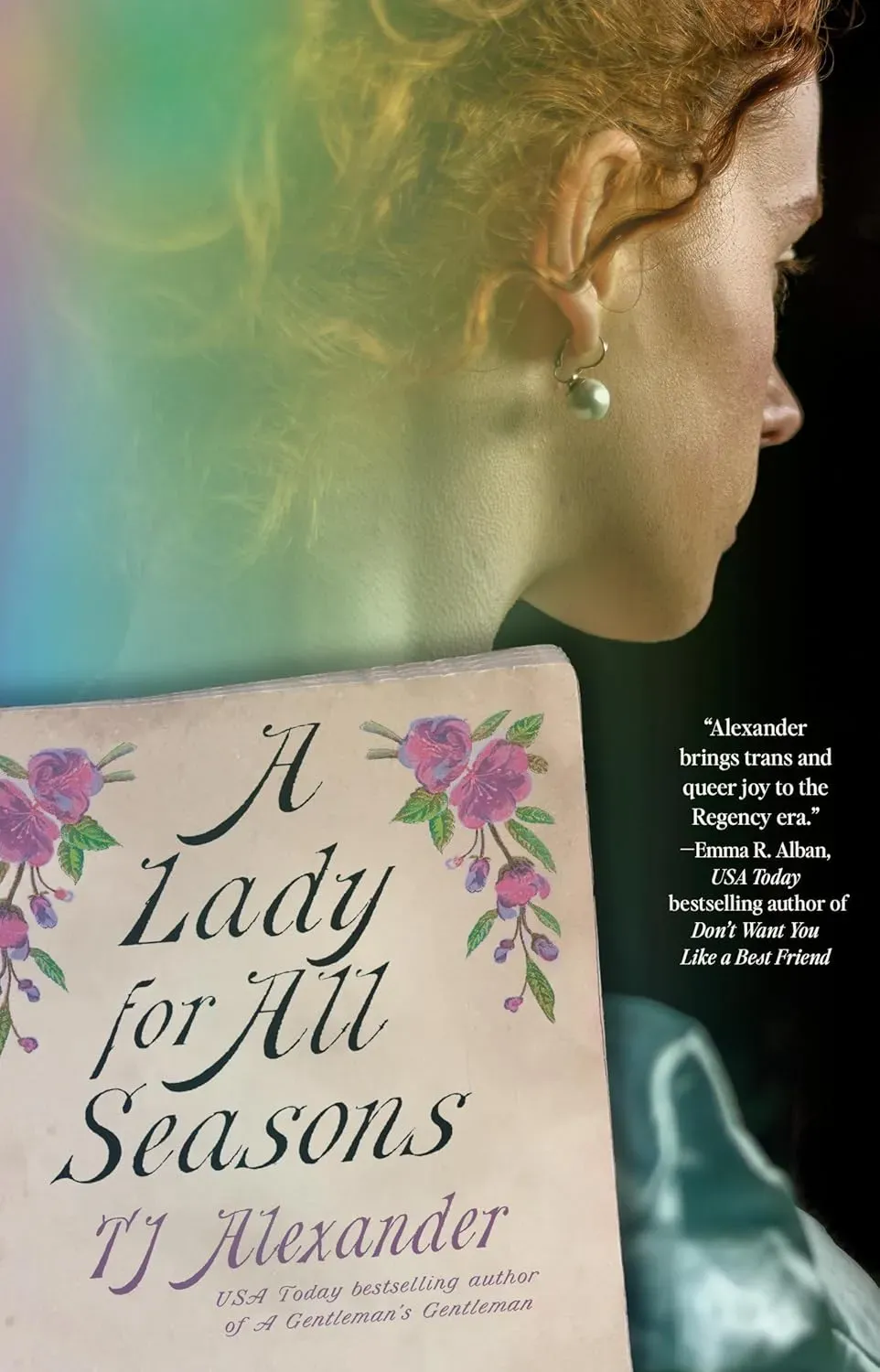 The cover for a Lady of All Seasons by TJ Alexander features a 1/4th profile of a woman with reddish brown hair in a Grecian bun facing away from the camera. A big pearl earring dangles from her visible ear. The title of the book is presented on what looks to be a the cover page of a vintage book with pink floral illustrations on both top corners.