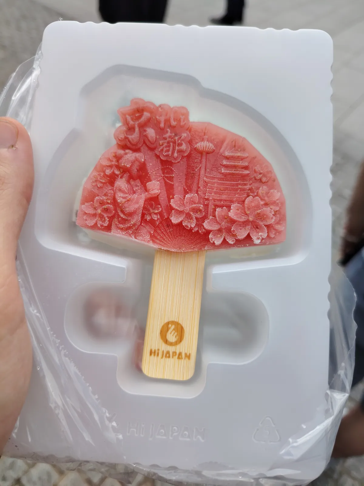 a red commemorative ice cream fan. There's a picture engraved in some solid red ice on the front of the fan, while the back is just regular vanilla ice cream.